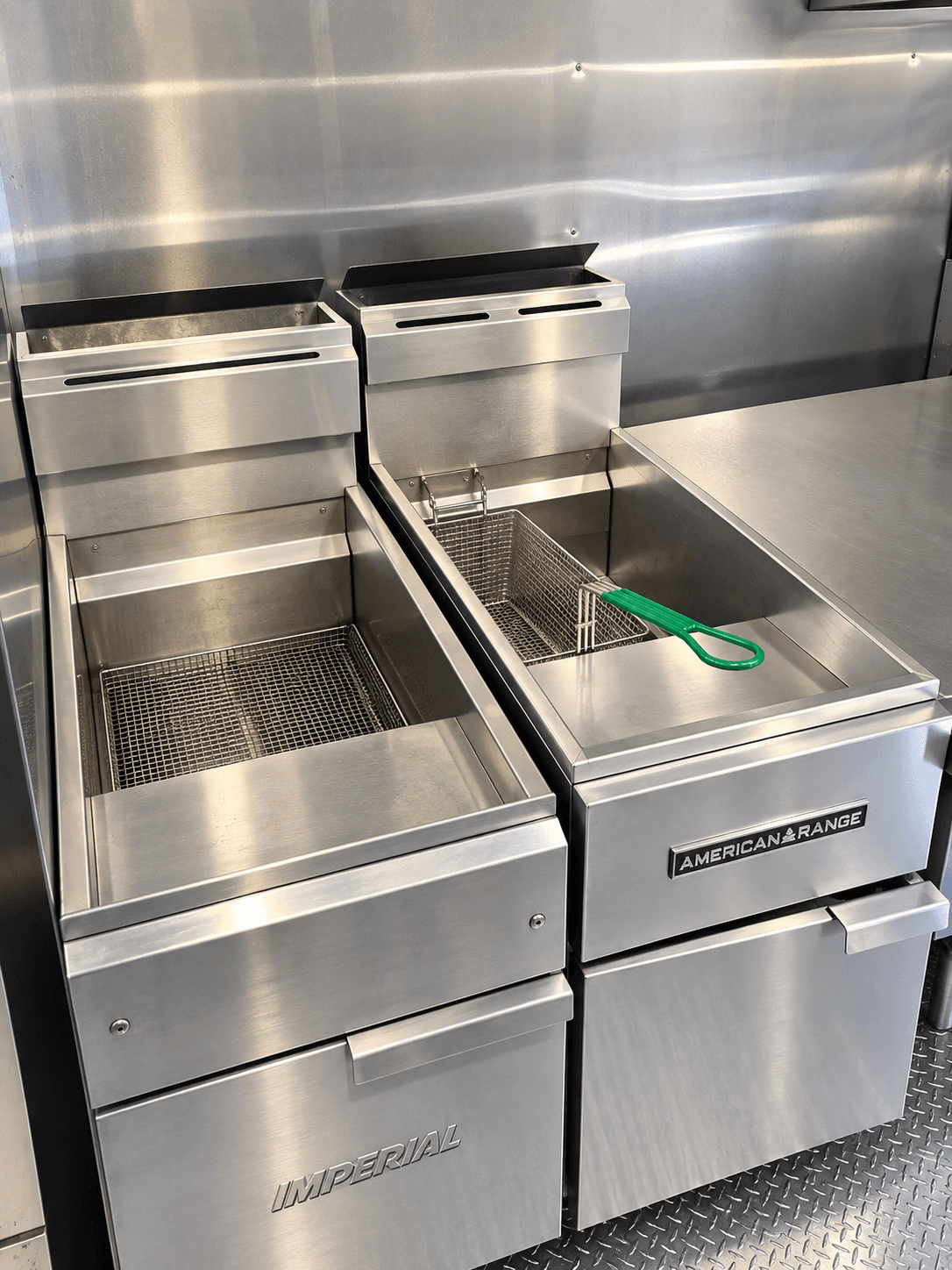 Commercial deep fryers beneath a kitchen extraction hood